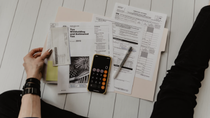 Person budgeting on paper with calculator